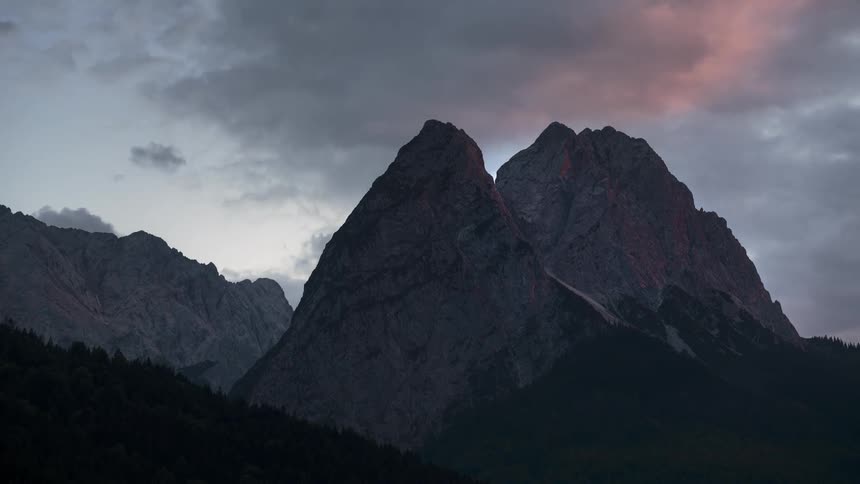 Towering mountains under a cloudy sky at dawn