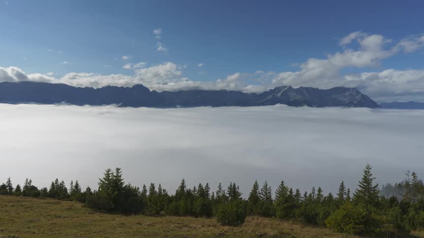 Time lapse of a landscape with a sea of clouds in the mountains under a clear sky above