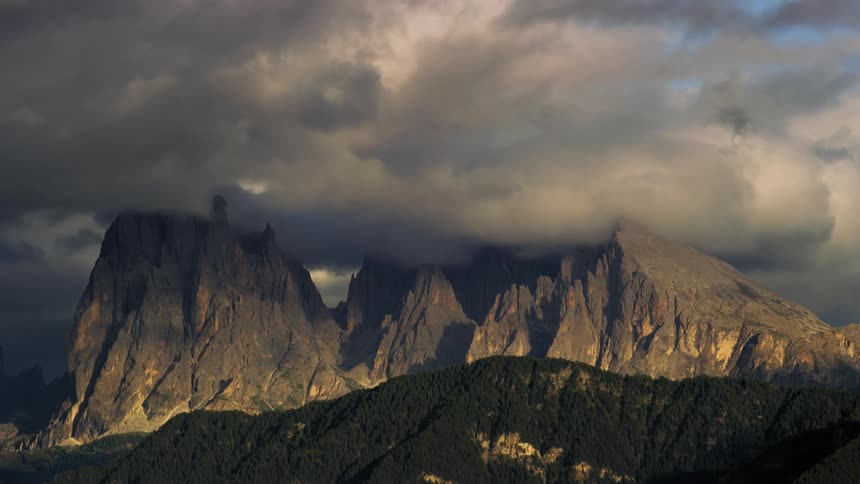 The clouds flow over the mountain range