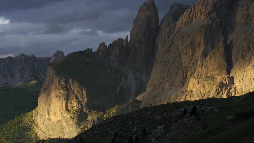 Rocky mountain range with erosions and misty clouds passing by