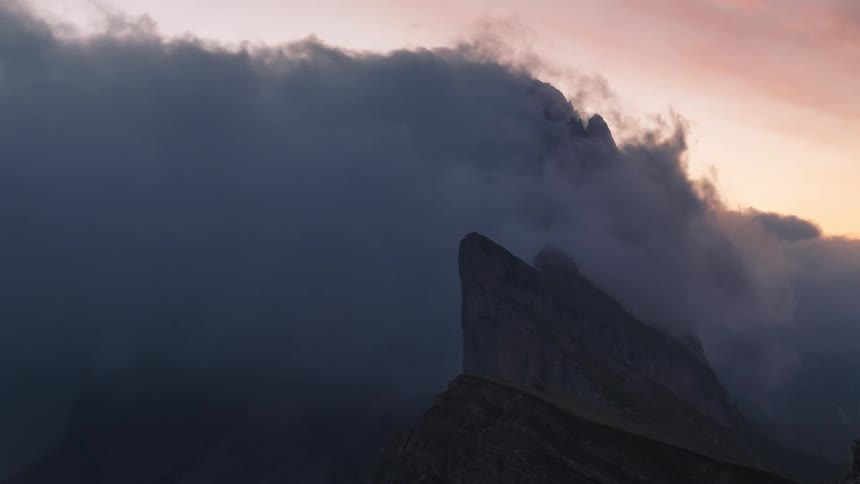 Sea of clouds passing over a rocky peak one morning