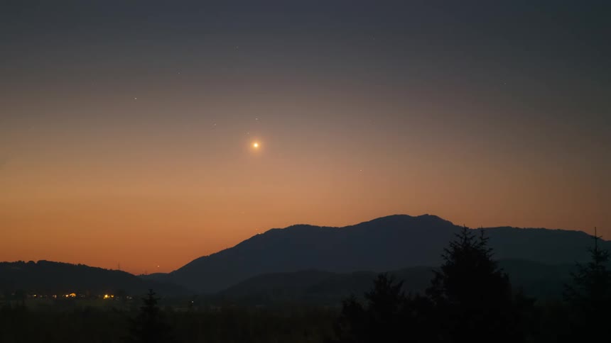 A landscape of a silhouette of a mountain and in the sky the orange sun is rising