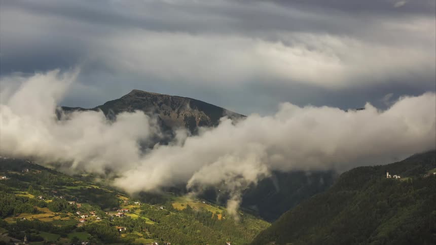 Mountains with greenish vegetation in cloudy clouds passing by