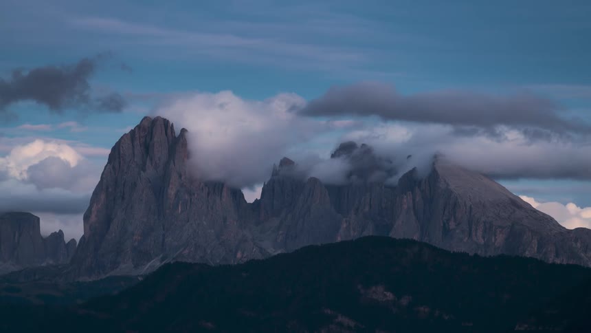 A thick cloud banks moves over an extensive mountain range