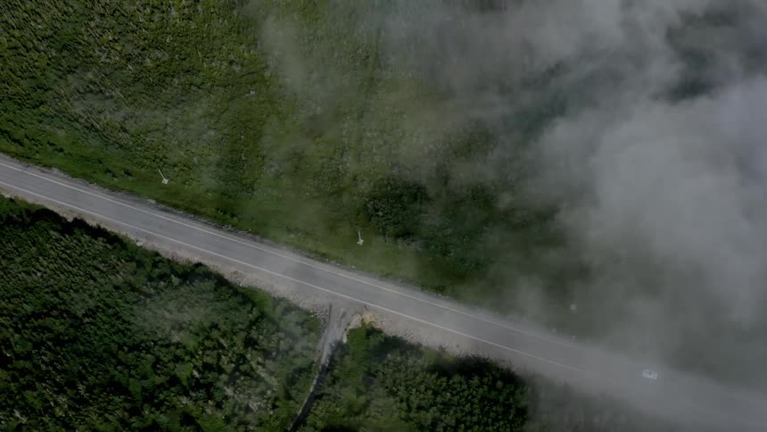 Aerial panorama of a narrow highway surrounded by greenery
