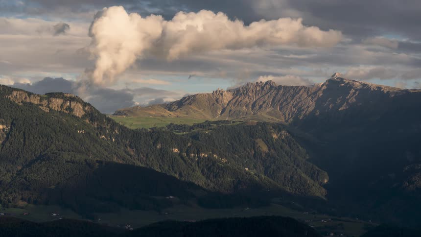 Mountainous landscape with sunlight partially falling on the slopes and valleys