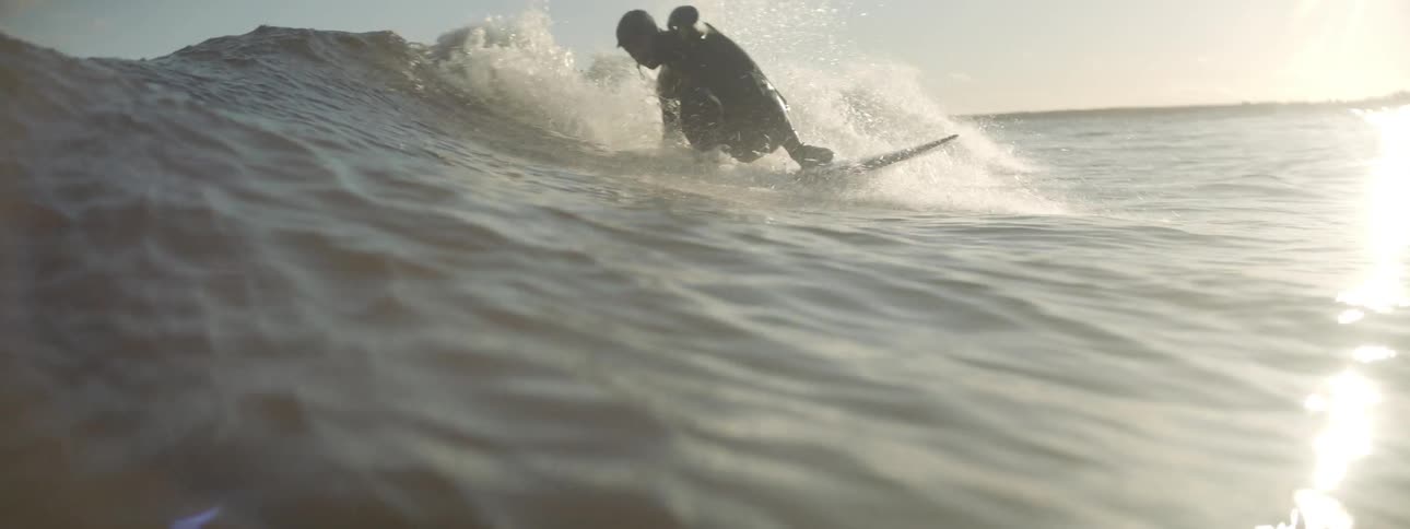 A man rides a wave on a surfboard