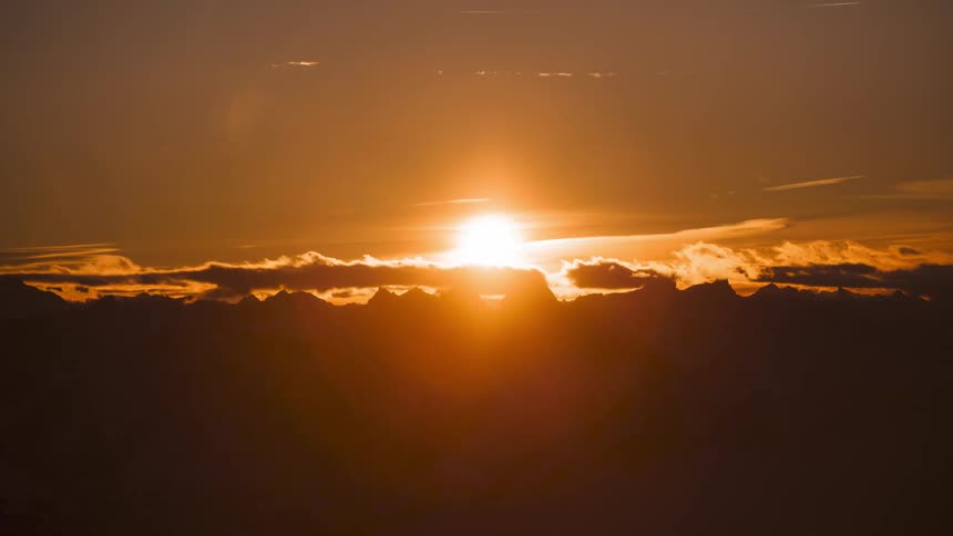 Airplanes zip across the sky as the sun shines brightly over a bank of clouds