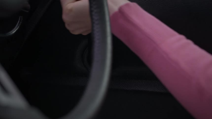 Female driver turns handle of manual window mechanism