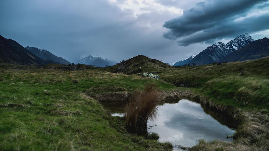Landscape of a cloudy sky passing through snowy mountains