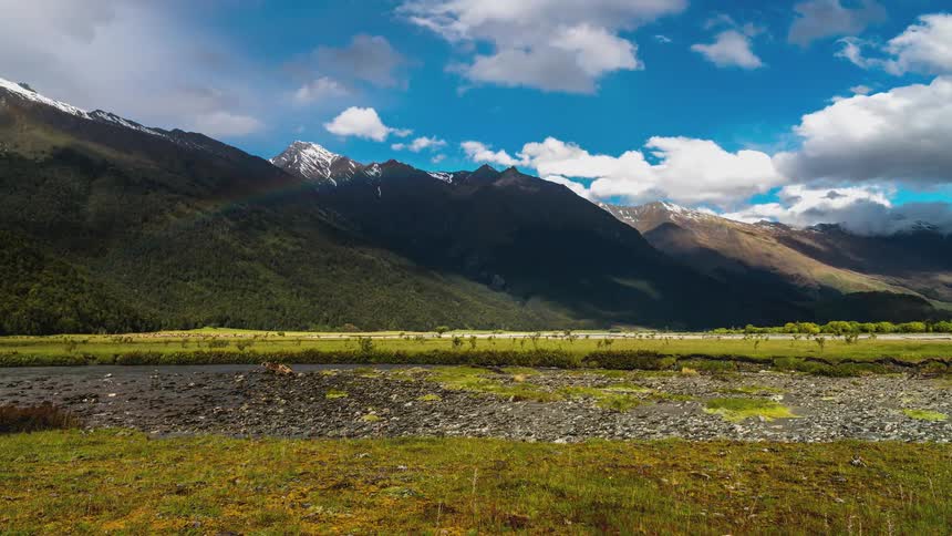 Clouds float over a small river in a mountain valley