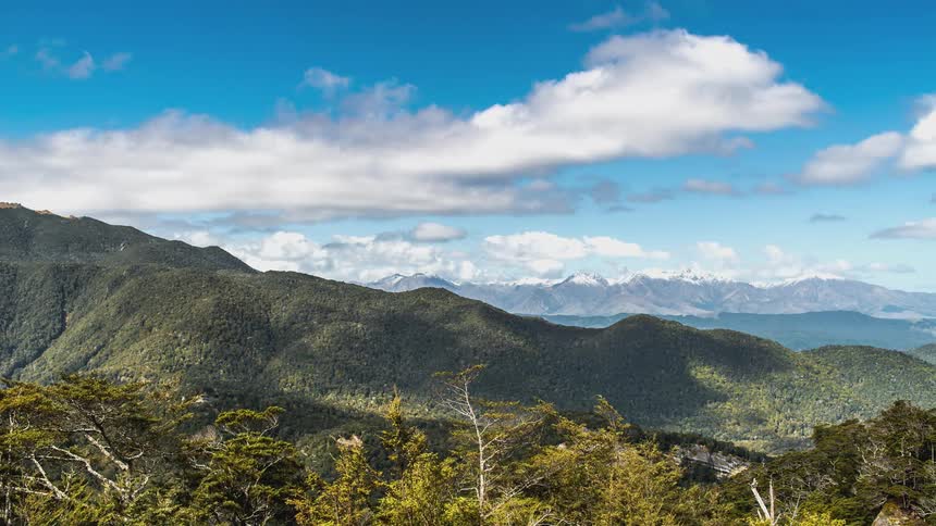 Clouds throw shadows on mountains and forests