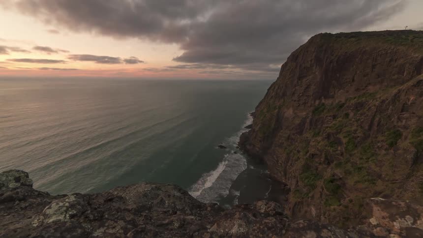 Time lapse of gentle waves reaching the cliffs on the coast at sunset