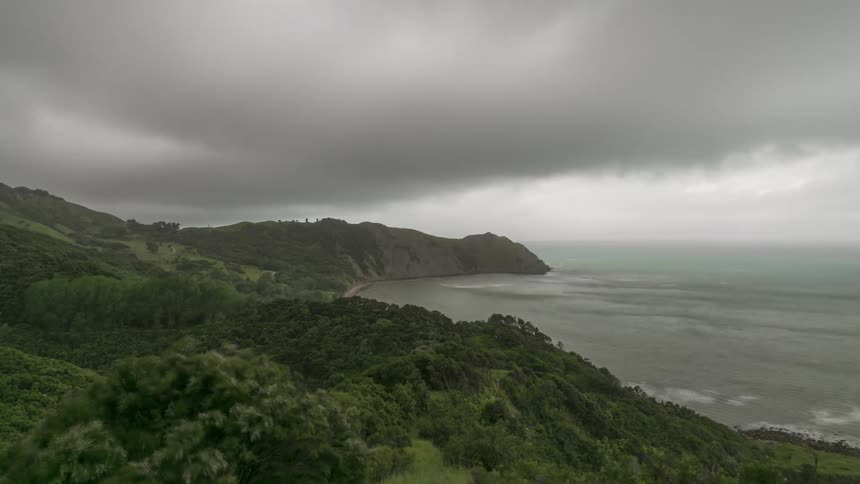 Time lapse of a thick layer of clouds rolling over a coastal landscape
