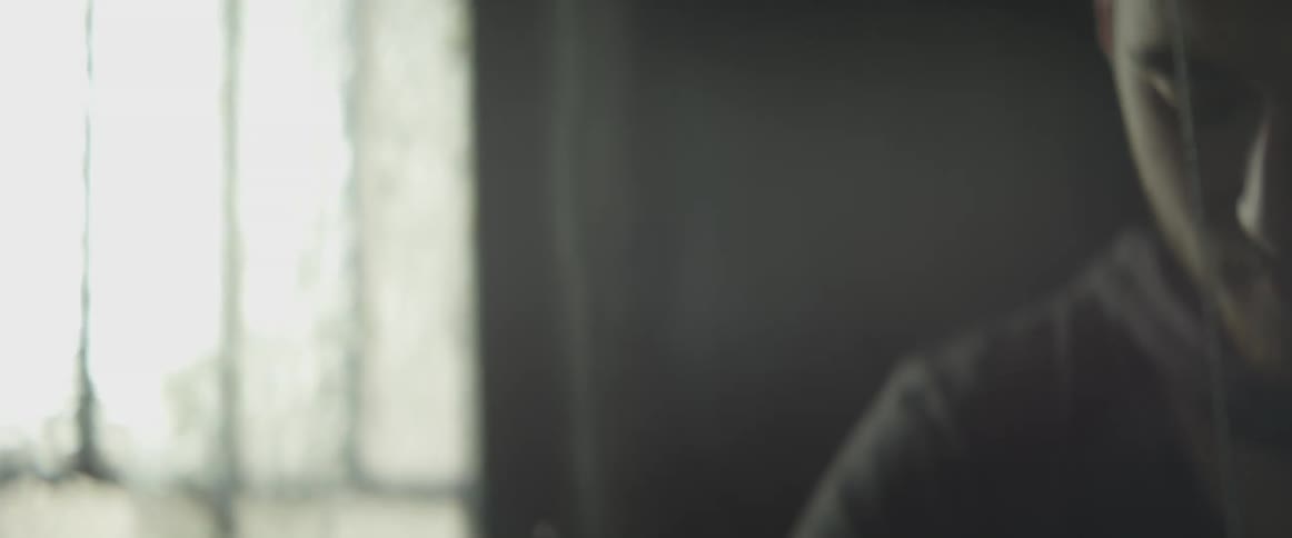 Man working on something in a dark room by a window