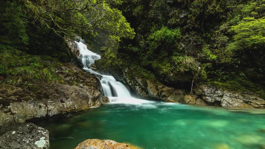 A waterfall pours into the stream