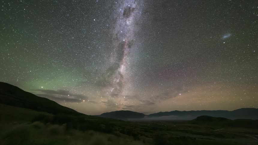 Landscape of green mountains against a starry sky