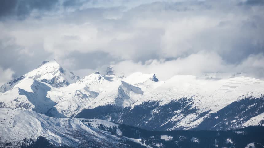 Clouds passing over a snow covered mountain range