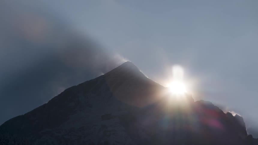 The sun is setting behind the mountain