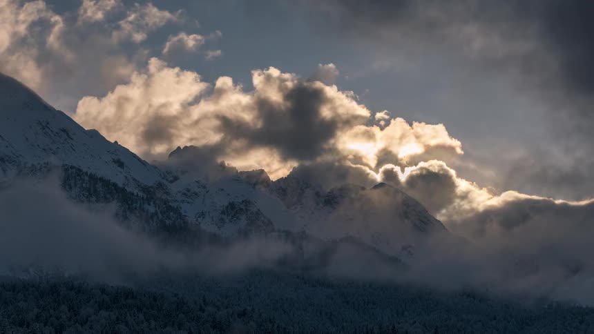 Snowy mountain ranges with conifers and a sea of clouds
