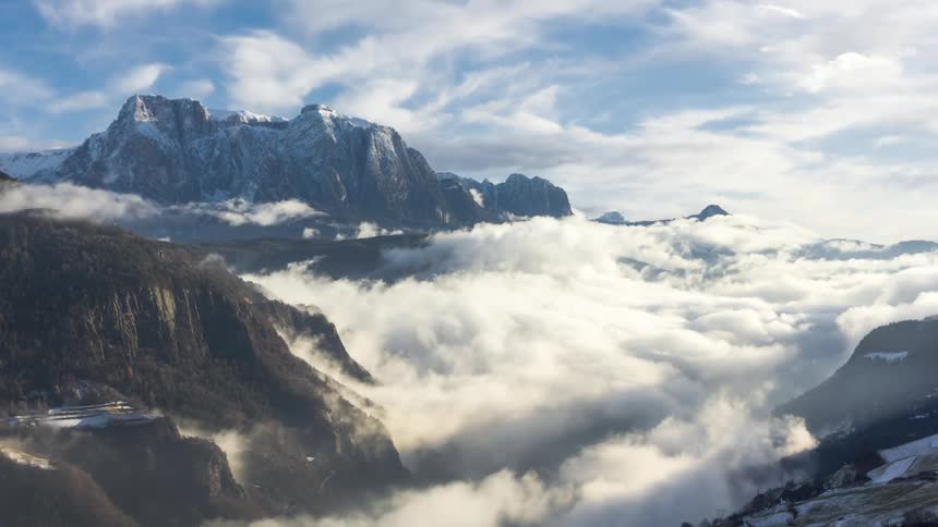 Mountainous landscape with snowcapped peaks emerging above a sea of clouds
