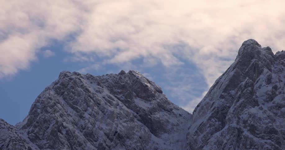 Mountain range with snowcapped peaks against a cloudy sky