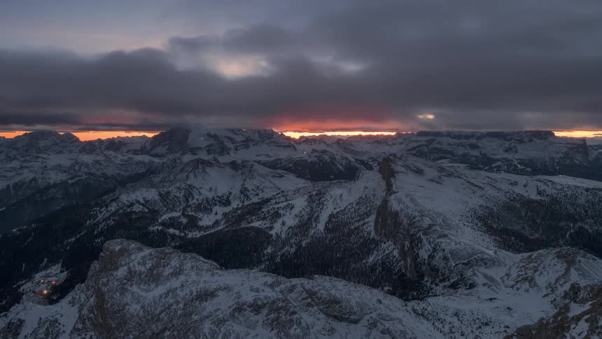Clouds move over a mountain range sprinkled in snow