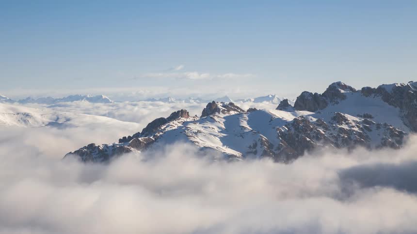 Dense clouds float over and around mountain ranges