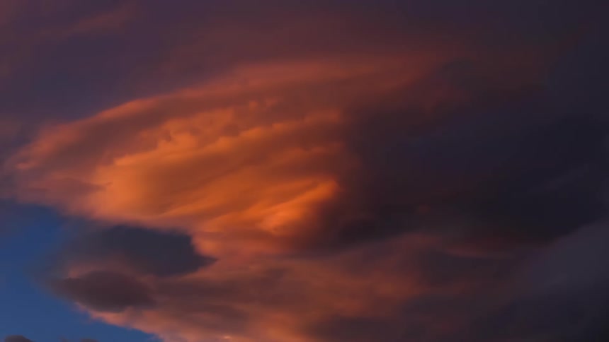 White clouds darken into storm clouds as the sun sets