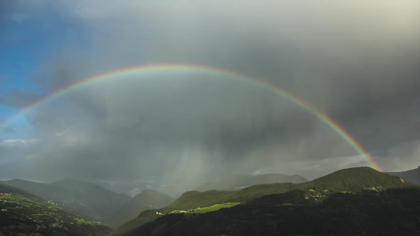 Rain clouds pass over causing a rainbow