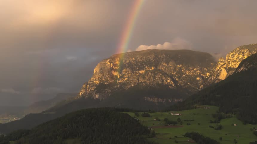 A double rainbow shining over a mountain and rural community