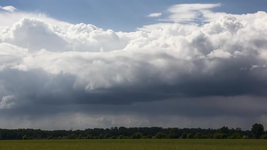 Vast field under a dramatic sky with dense clouds