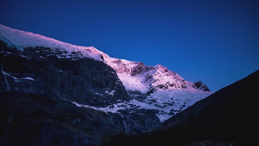 Mountains covered in snow and the day dawning