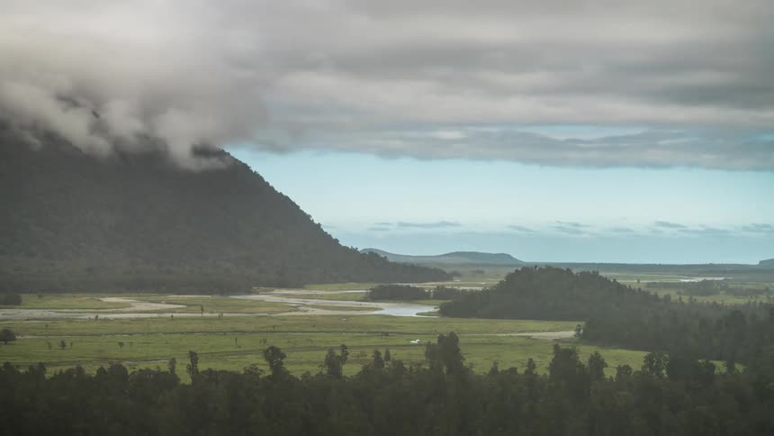 Mountains with conifers around and cloudy clouds
