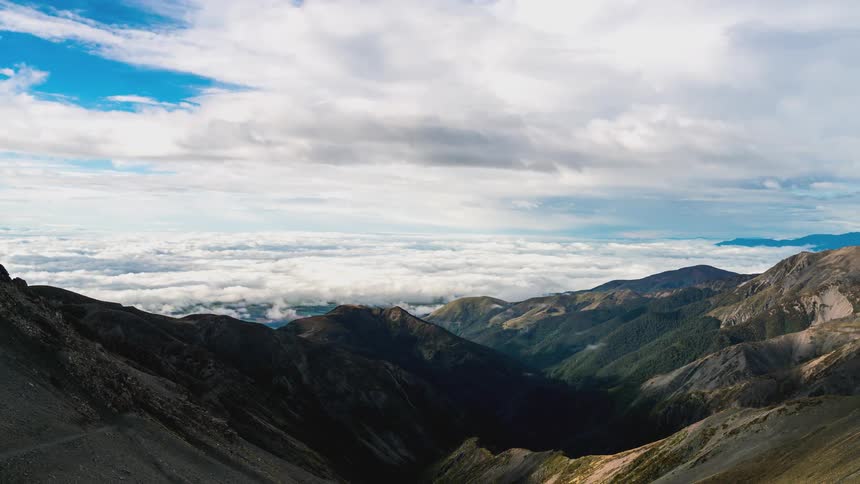 White clouds float over a large mountain valley