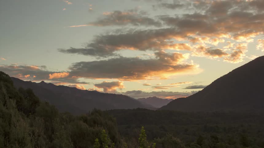 Landscape of mountains and forests against a dawn sky