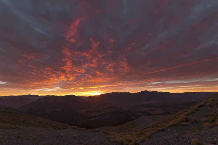 Mountain landscape with the sun rising on the horizon