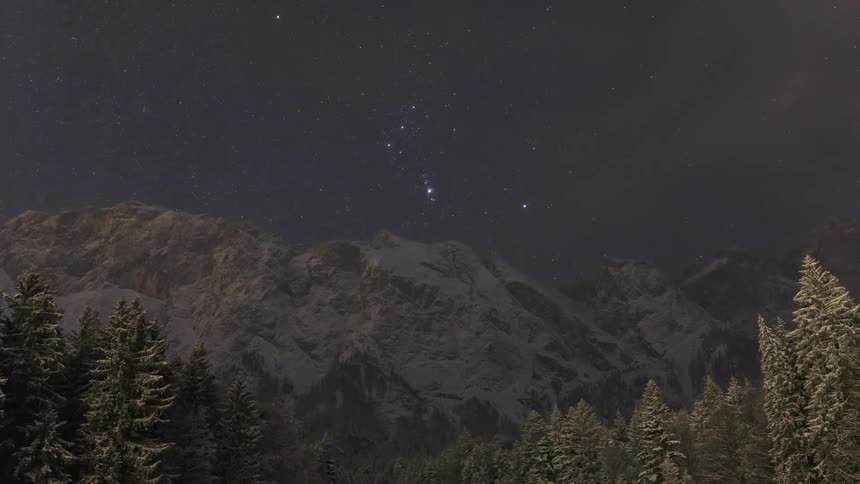 The sun sets and the stars come out above the mountains