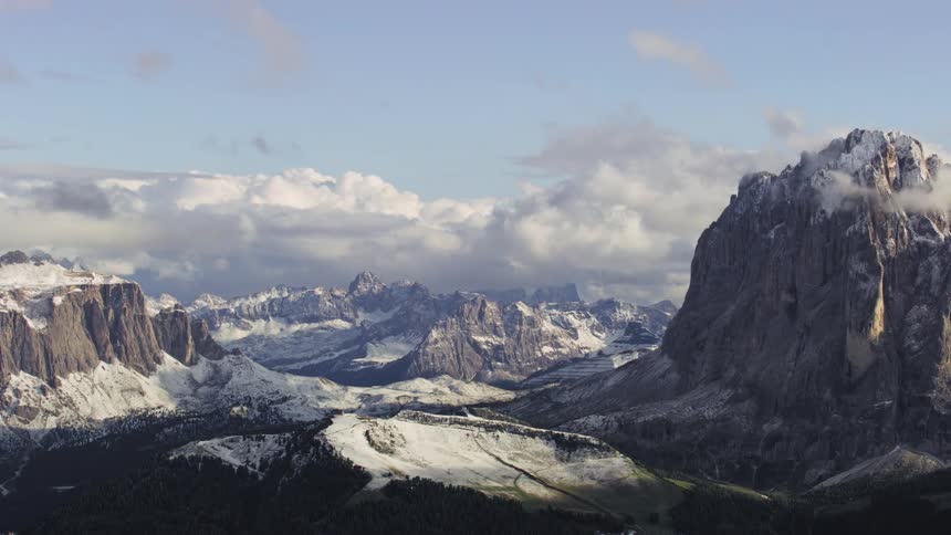 Clouds flow over the snow covered mountains
