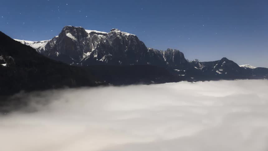 Clouds flow over the mountain summit
