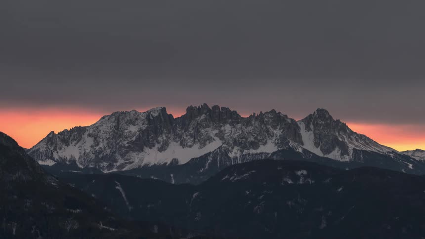 Snowy mountains with reddish dusk sky