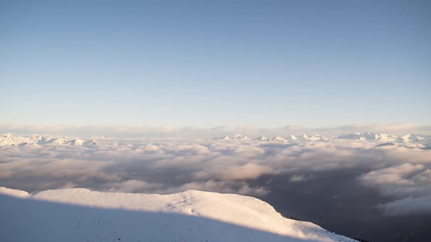 A view above the clouds where they are white and heading to the right