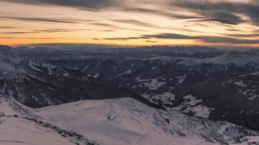 Snowy mountain range and the setting sun