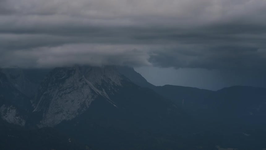 Silhouette of mountains with nebulous clouds passing by