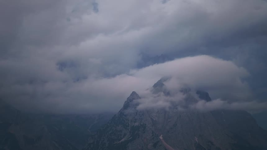 Imposing mountain partially covered by dense clouds with a dramatic sky