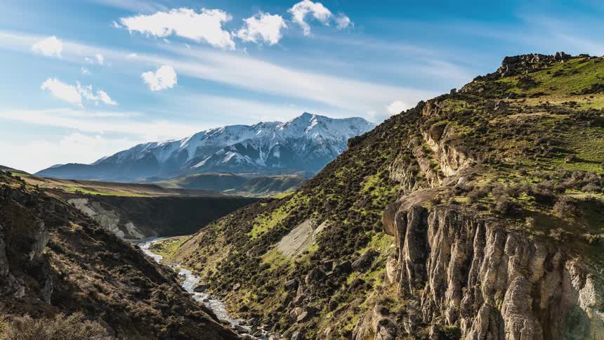 Clouds over a stream running between mountains