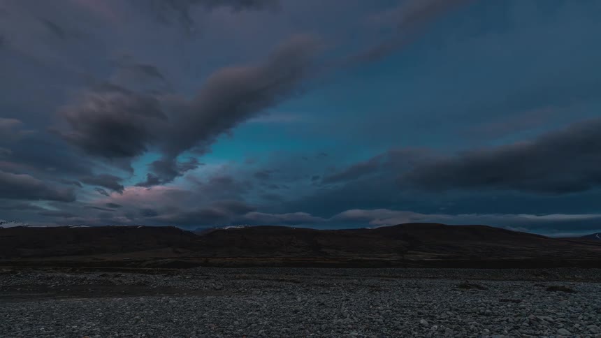 Mountain range with clouds passing by and the day dusk