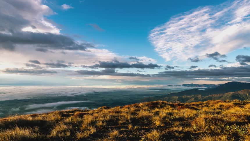 Time lapse over a landscape of plains and mountains under a blue sky