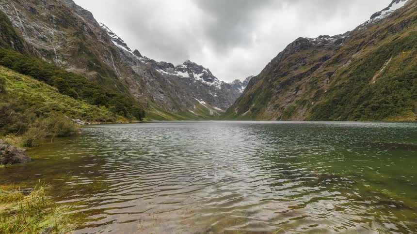 Storm clouds move over a river running through a mountain valley