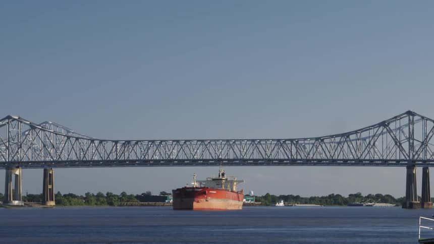 Large boat passing under a bridge expansion on a clear day